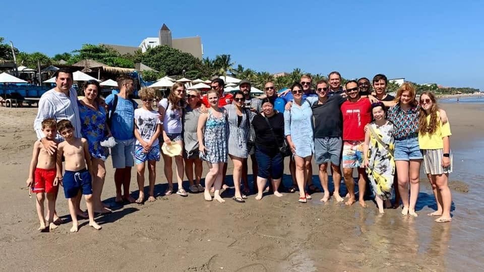A big group of us lined up on a beach in Bali