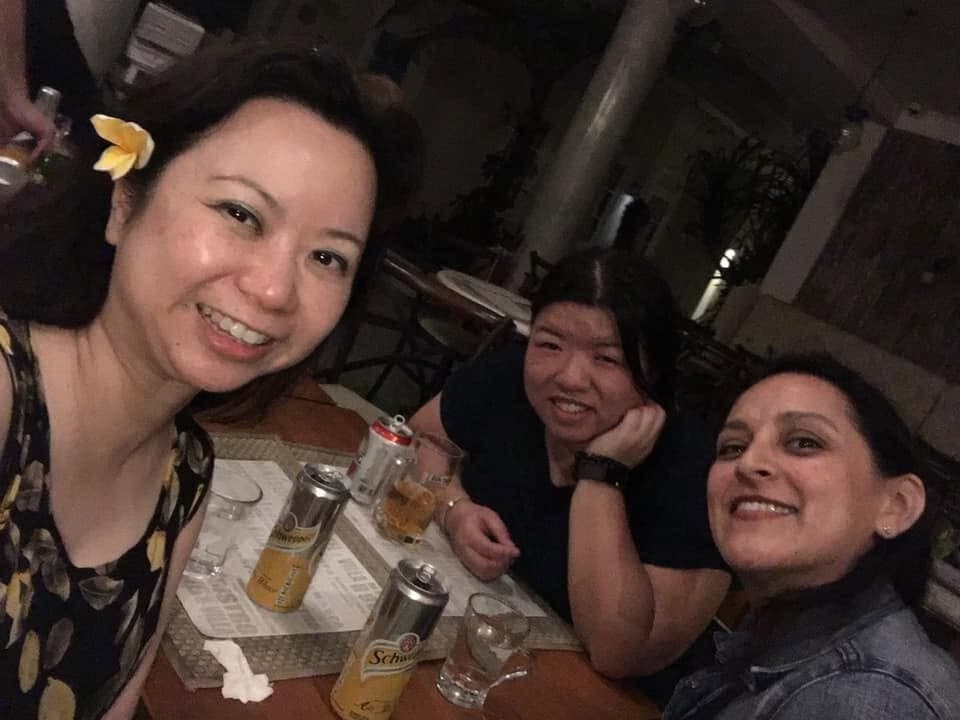 Three of us smiling over drinks at a café table