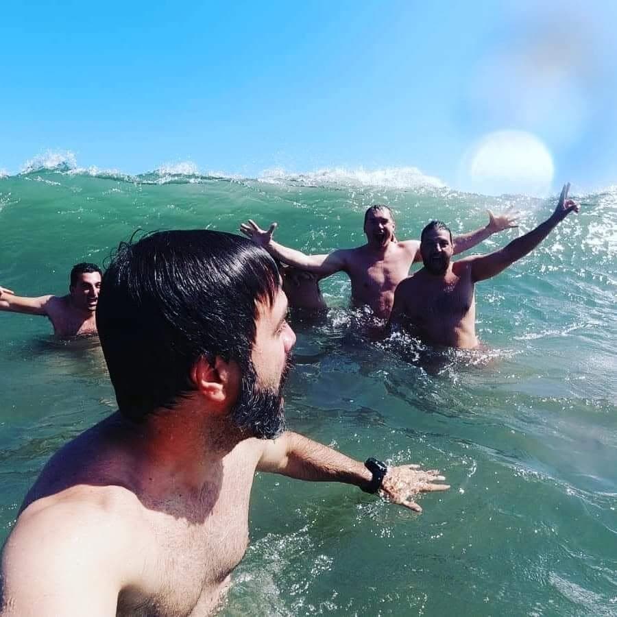 A few of us playing in big waves, arms up
