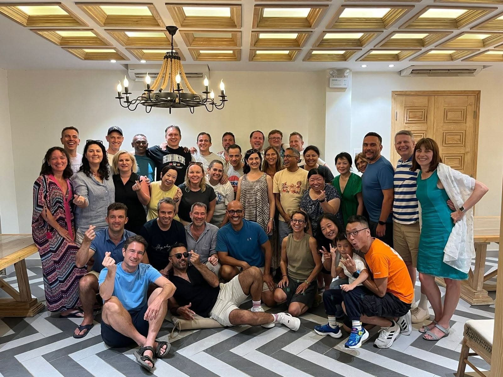 About forty of us at GAMMA 2025 in Da Nang, crowded together in one room, many making finger hearts at the camera