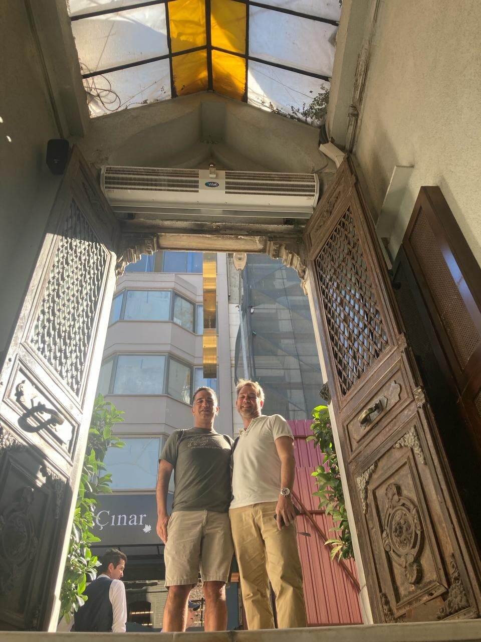 Two of us under a tall carved wooden doorway